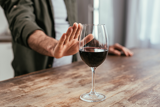 man refusing glass of red wine