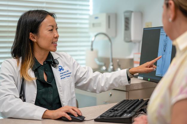 Nina Nyugen, MD consults with a patient